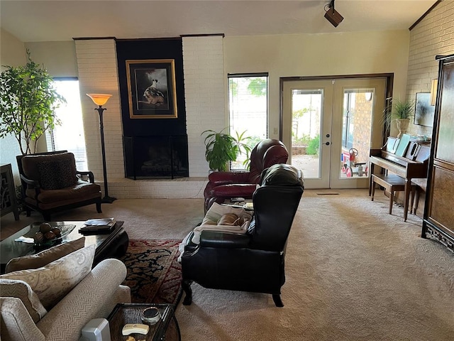 living room featuring light colored carpet, a fireplace, brick wall, and french doors