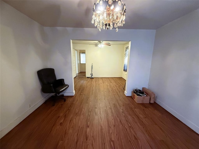 unfurnished dining area featuring hardwood / wood-style floors and ceiling fan with notable chandelier