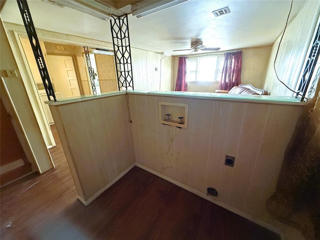 laundry room with wooden walls, ceiling fan, dark wood-type flooring, and washer hookup