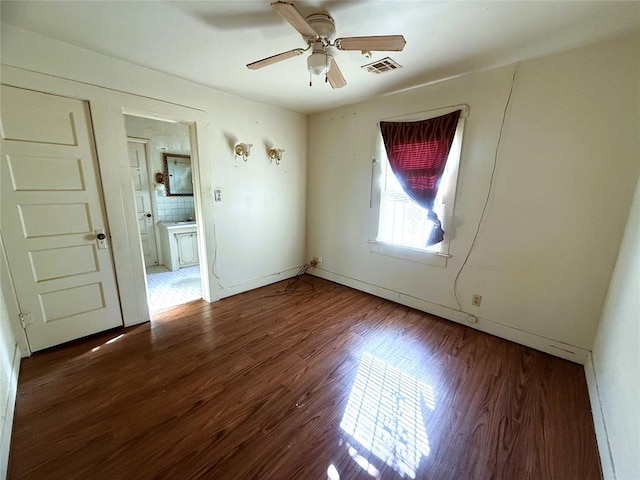 empty room with dark hardwood / wood-style floors and ceiling fan