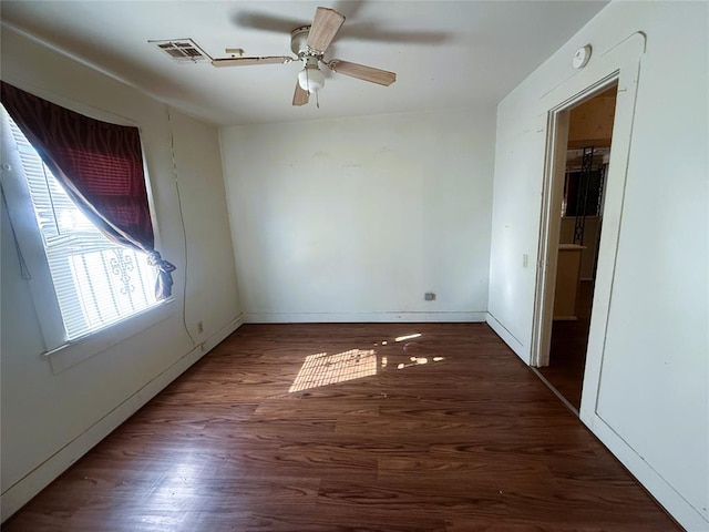 spare room featuring ceiling fan and dark hardwood / wood-style floors