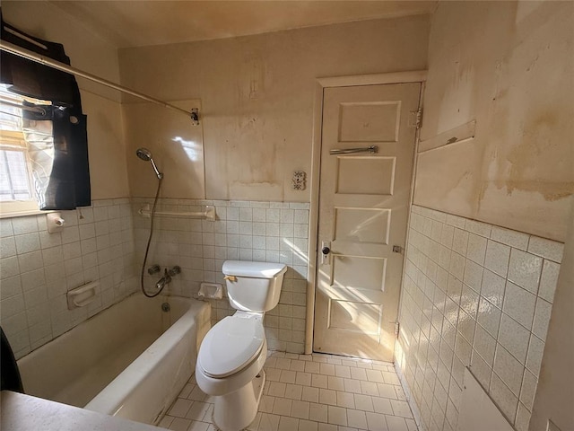bathroom with toilet, shower / washtub combination, tile patterned floors, and tile walls
