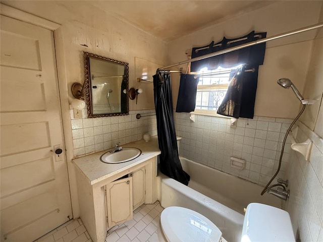full bathroom with tile patterned floors, vanity, toilet, and tile walls
