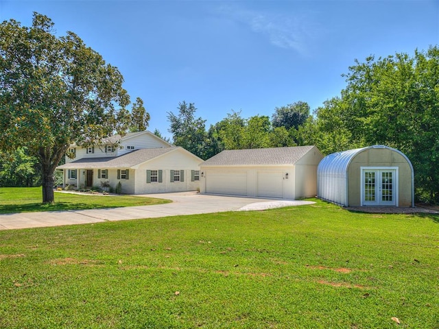 single story home featuring french doors, an outbuilding, a front yard, and a garage