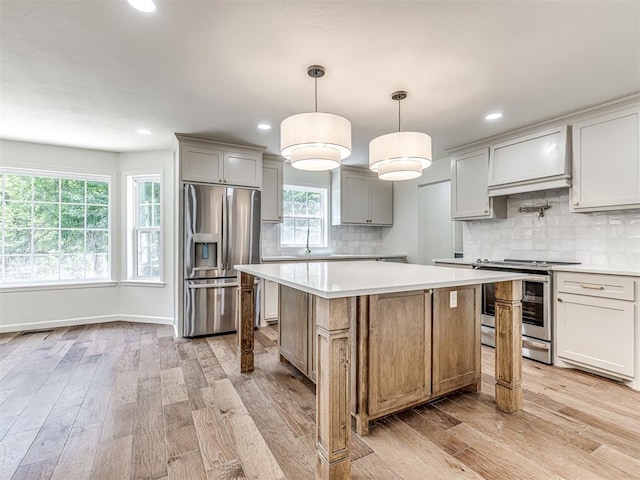 kitchen featuring pendant lighting, a center island, light wood-type flooring, custom range hood, and stainless steel appliances