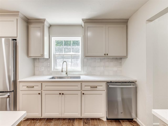 kitchen featuring stainless steel appliances, tasteful backsplash, hardwood / wood-style flooring, and sink