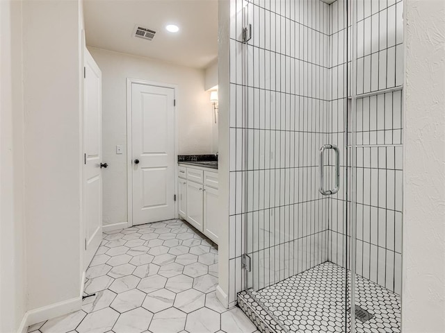 bathroom with tile patterned floors, vanity, and a shower with door