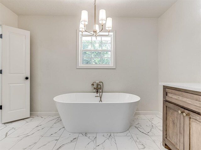 bathroom featuring a tub, vanity, and a notable chandelier