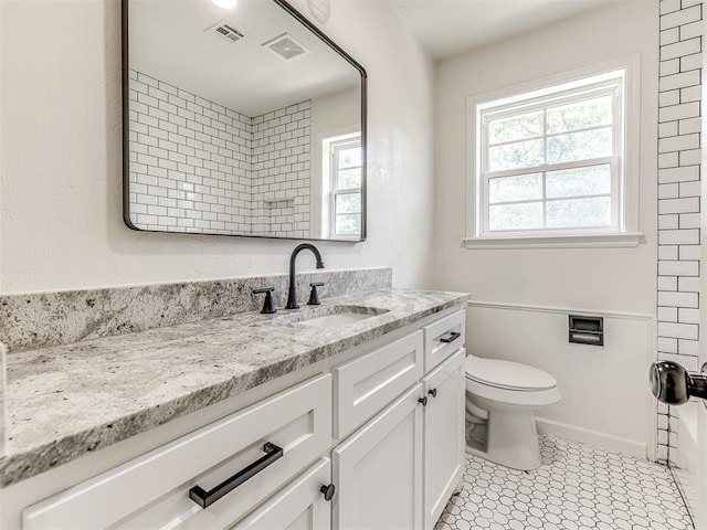 bathroom with tile patterned flooring, vanity, and toilet