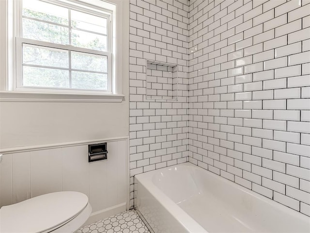 bathroom with tile patterned floors, toilet, and tiled shower / bath