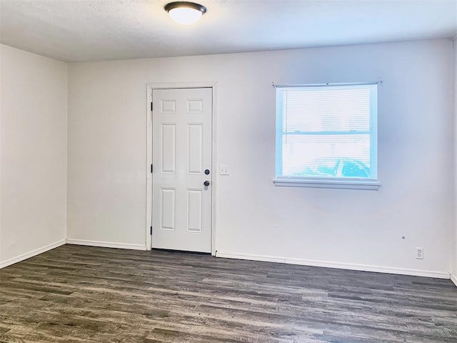 unfurnished room featuring dark wood-type flooring