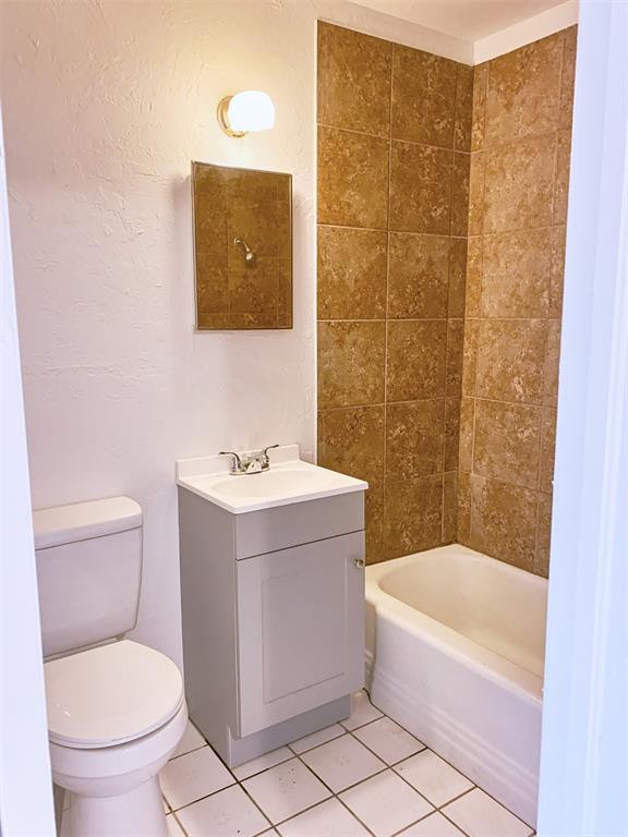 full bathroom with tile patterned flooring, vanity, toilet, and tiled shower / bath combo