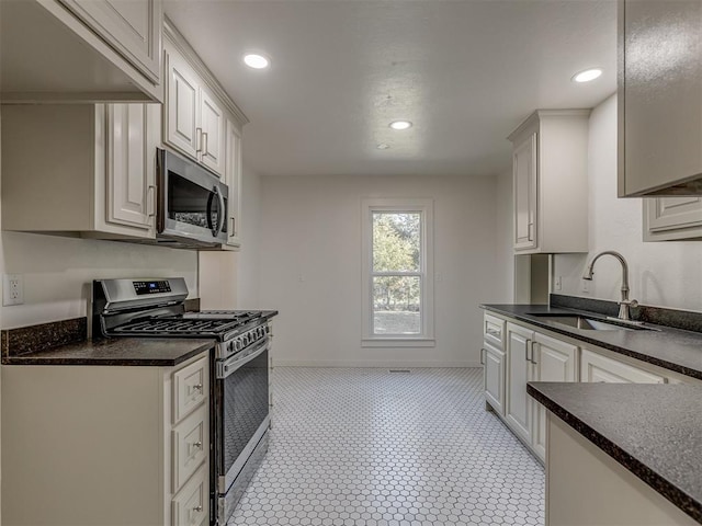 309 S 6th St, Kingfisher, OK 73750 - kitchen with appliances with stainless steel finishes, dark countertops, a sink, recessed lighting, and baseboards