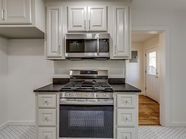 kitchen featuring white cabinets, stainless steel appliances, and light tile patterned floors