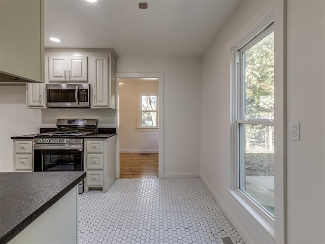 309 S 6th St, Kingfisher, OK 73750 - kitchen with stainless steel appliances, dark countertops, baseboards, recessed lighting, and light flooring