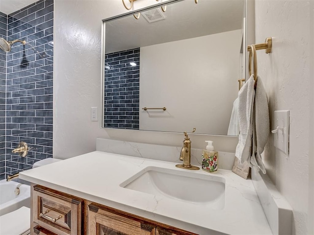 full bathroom featuring vanity, tiled shower / bath combo, and toilet