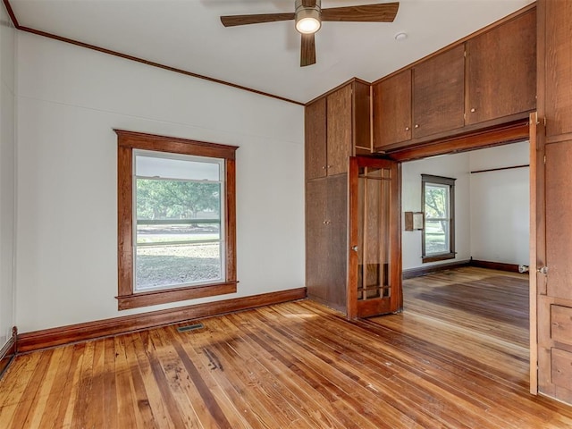 unfurnished room featuring ceiling fan, light hardwood / wood-style flooring, and crown molding