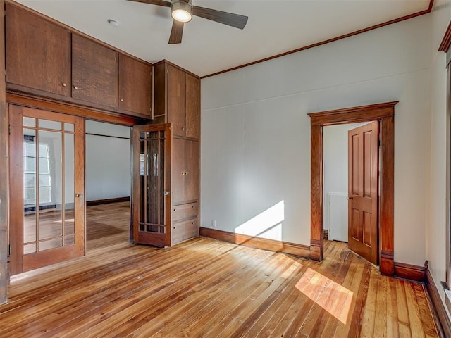 spare room featuring ceiling fan, crown molding, light hardwood / wood-style floors, and french doors