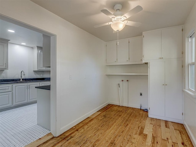 clothes washing area featuring light hardwood / wood-style flooring, ceiling fan, a healthy amount of sunlight, and sink