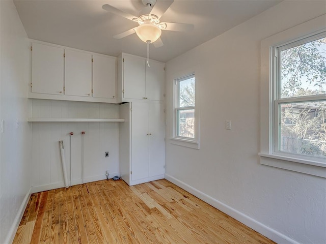 laundry area with ceiling fan, cabinets, hookup for an electric dryer, hookup for a washing machine, and light wood-type flooring