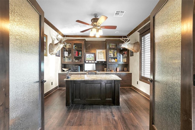 home office with crown molding, ceiling fan, and dark hardwood / wood-style floors