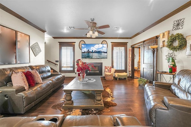 living room featuring dark hardwood / wood-style floors, ceiling fan, and crown molding