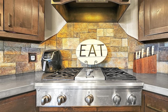 kitchen featuring stainless steel gas stovetop, backsplash, and range hood