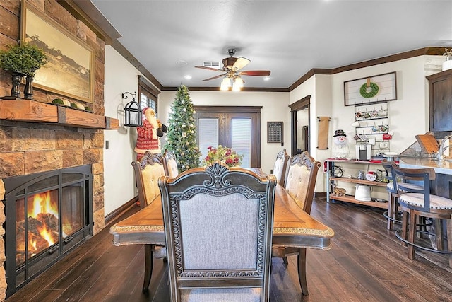 dining room featuring ceiling fan, a fireplace, dark wood-type flooring, and ornamental molding