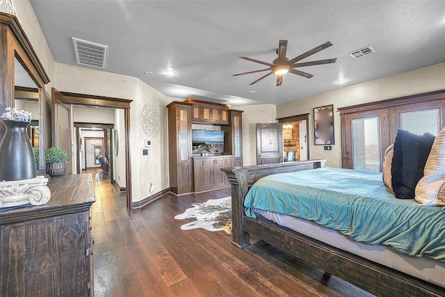 bedroom with ceiling fan, french doors, dark hardwood / wood-style floors, and a textured ceiling