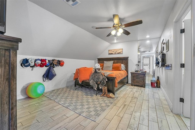 bedroom with ceiling fan, light hardwood / wood-style floors, and vaulted ceiling