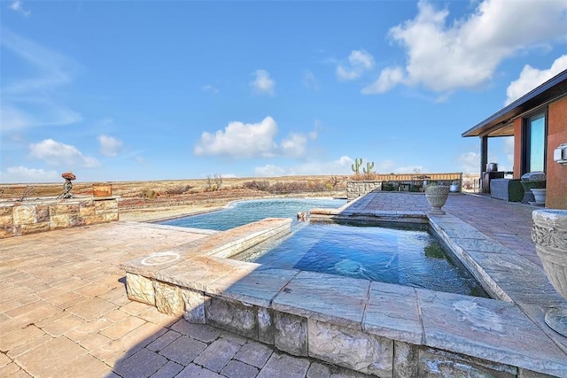 view of pool featuring pool water feature and a patio