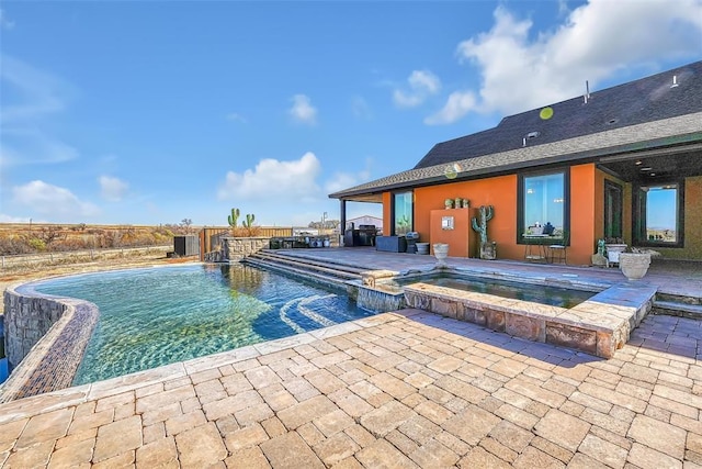 view of pool featuring pool water feature, an in ground hot tub, and a patio