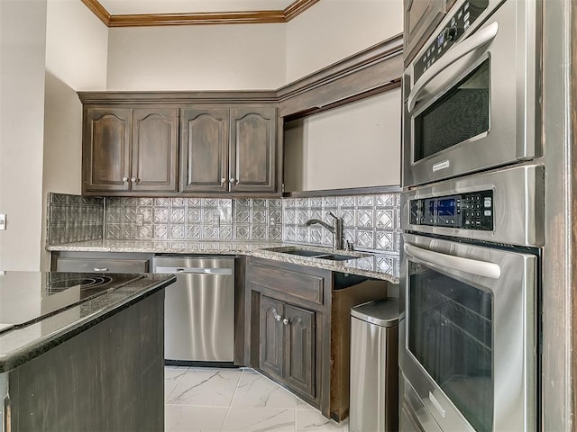 kitchen featuring appliances with stainless steel finishes, backsplash, stone countertops, dark brown cabinetry, and sink