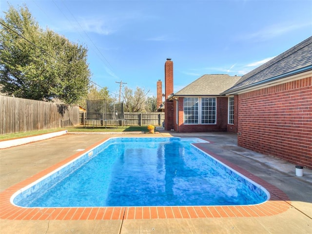 view of pool featuring a patio and a trampoline