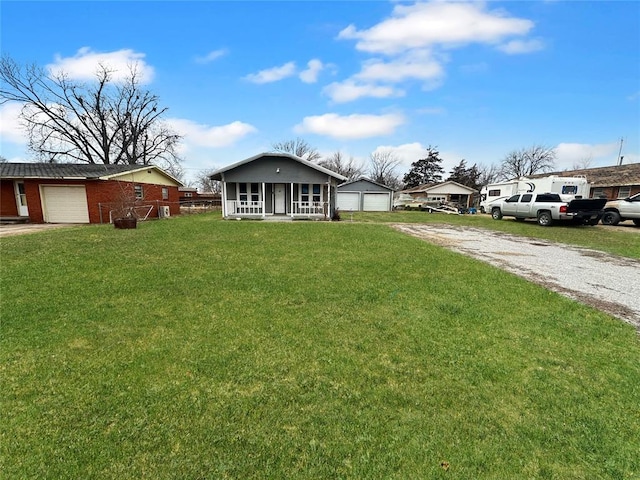 view of front of property with a front yard, a garage, and a porch