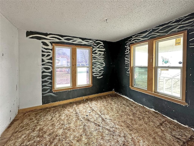 carpeted empty room featuring a textured ceiling