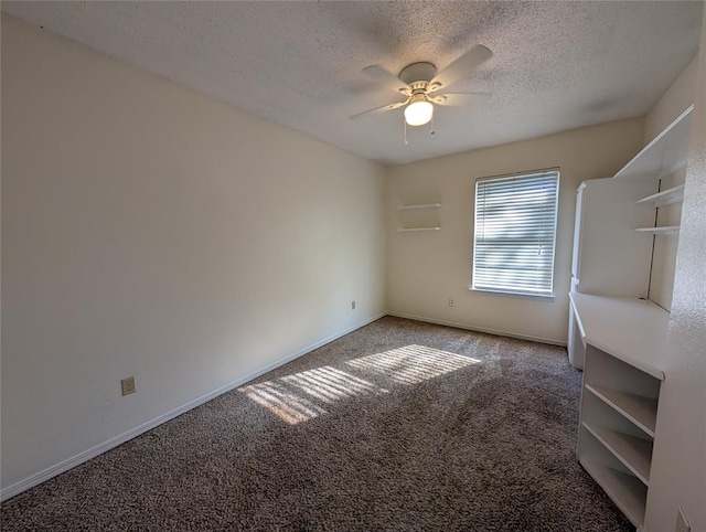 carpeted spare room with a textured ceiling and ceiling fan