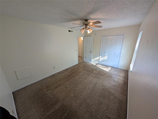 carpeted spare room featuring a textured ceiling and ceiling fan