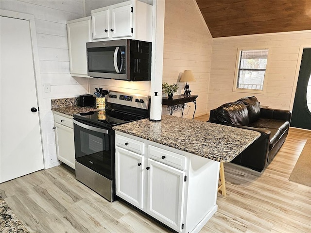 kitchen featuring kitchen peninsula, stainless steel appliances, vaulted ceiling, light hardwood / wood-style floors, and white cabinetry