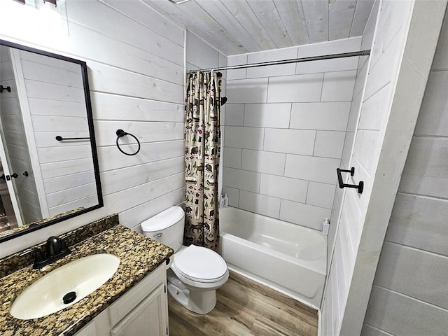 full bathroom with shower / bathtub combination with curtain, wood-type flooring, toilet, wooden walls, and vanity