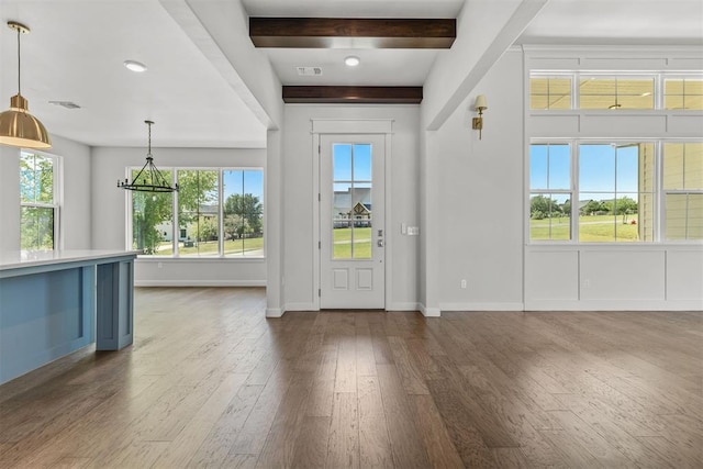 foyer entrance with dark wood-type flooring, beamed ceiling, visible vents, and baseboards