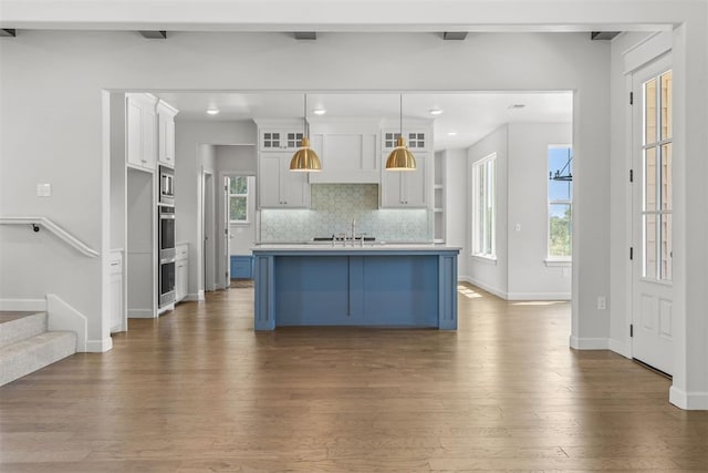 kitchen featuring appliances with stainless steel finishes, backsplash, dark wood-style flooring, light countertops, and beam ceiling