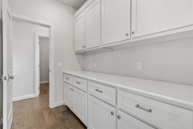 interior space featuring baseboards and dark wood-type flooring