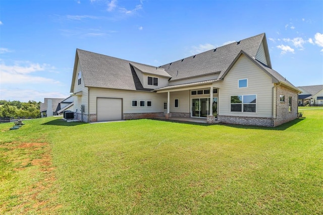 back of property with central air condition unit, a garage, a shingled roof, driveway, and a lawn