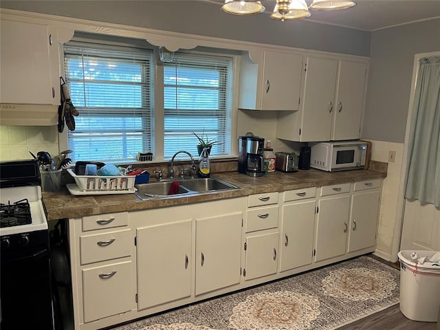 kitchen with white cabinetry, sink, white appliances, decorative backsplash, and hardwood / wood-style flooring