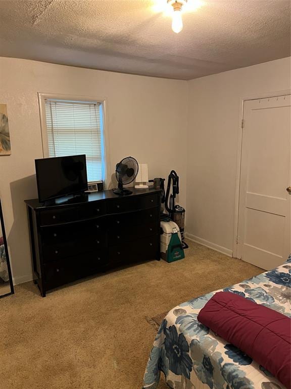 bedroom with light carpet and a textured ceiling