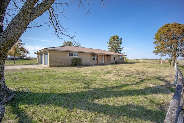 rear view of property featuring a garage and a yard