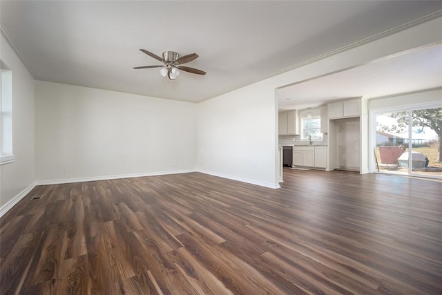 unfurnished living room featuring ceiling fan, dark wood-type flooring, and ornamental molding