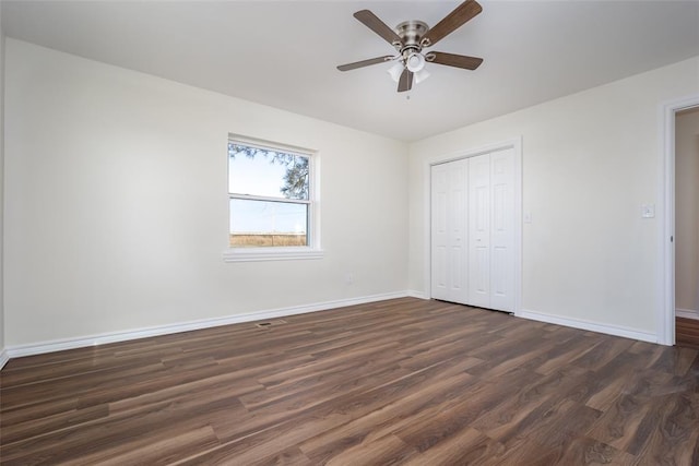 unfurnished bedroom with ceiling fan, dark hardwood / wood-style flooring, and a closet