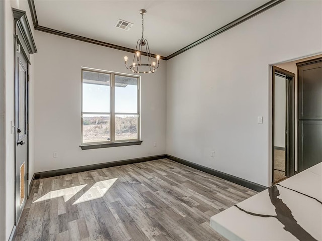 interior space featuring light hardwood / wood-style floors, crown molding, and a notable chandelier